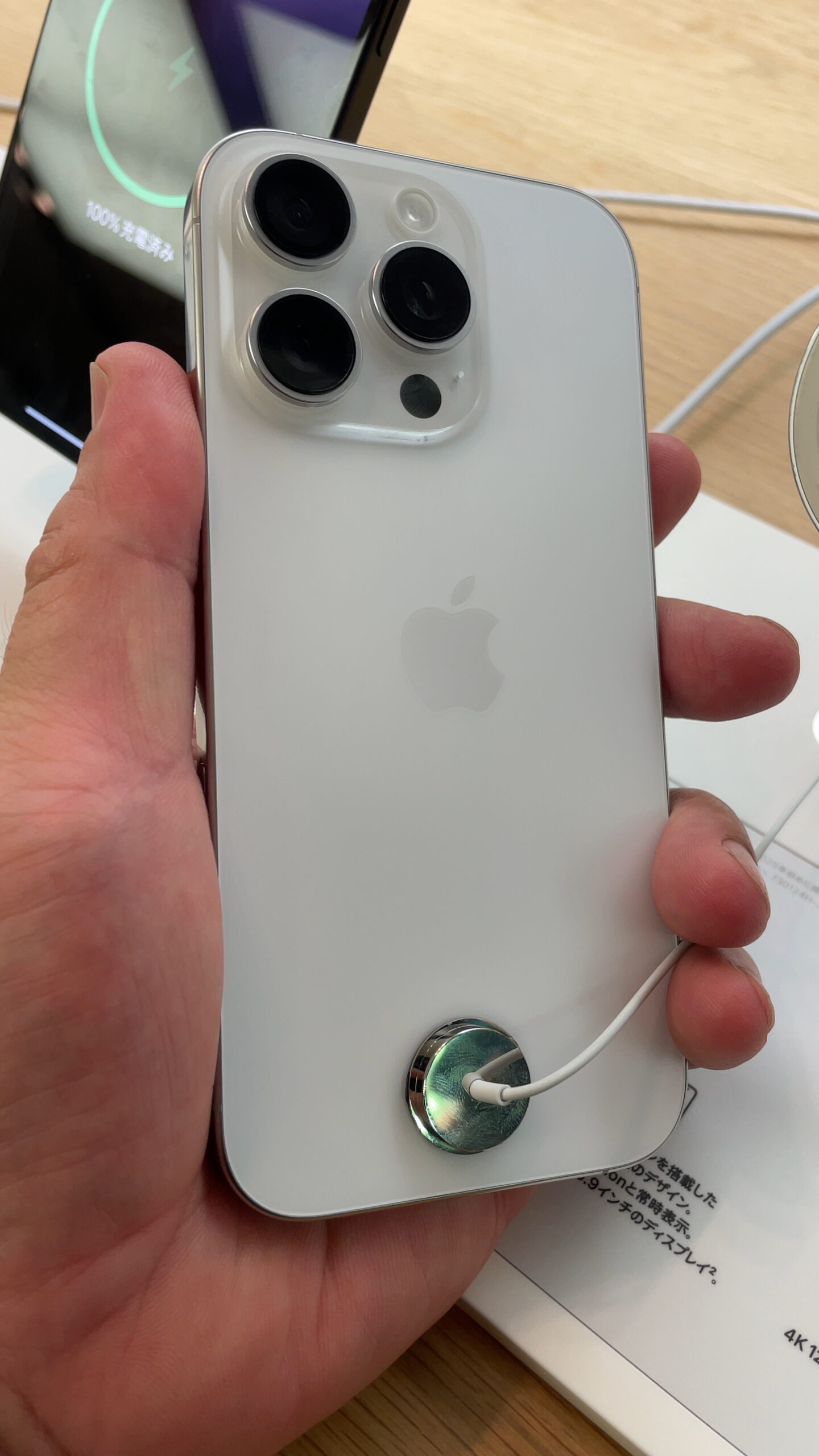 Hand holding an iPhone 16 Pro showing its triple camera system