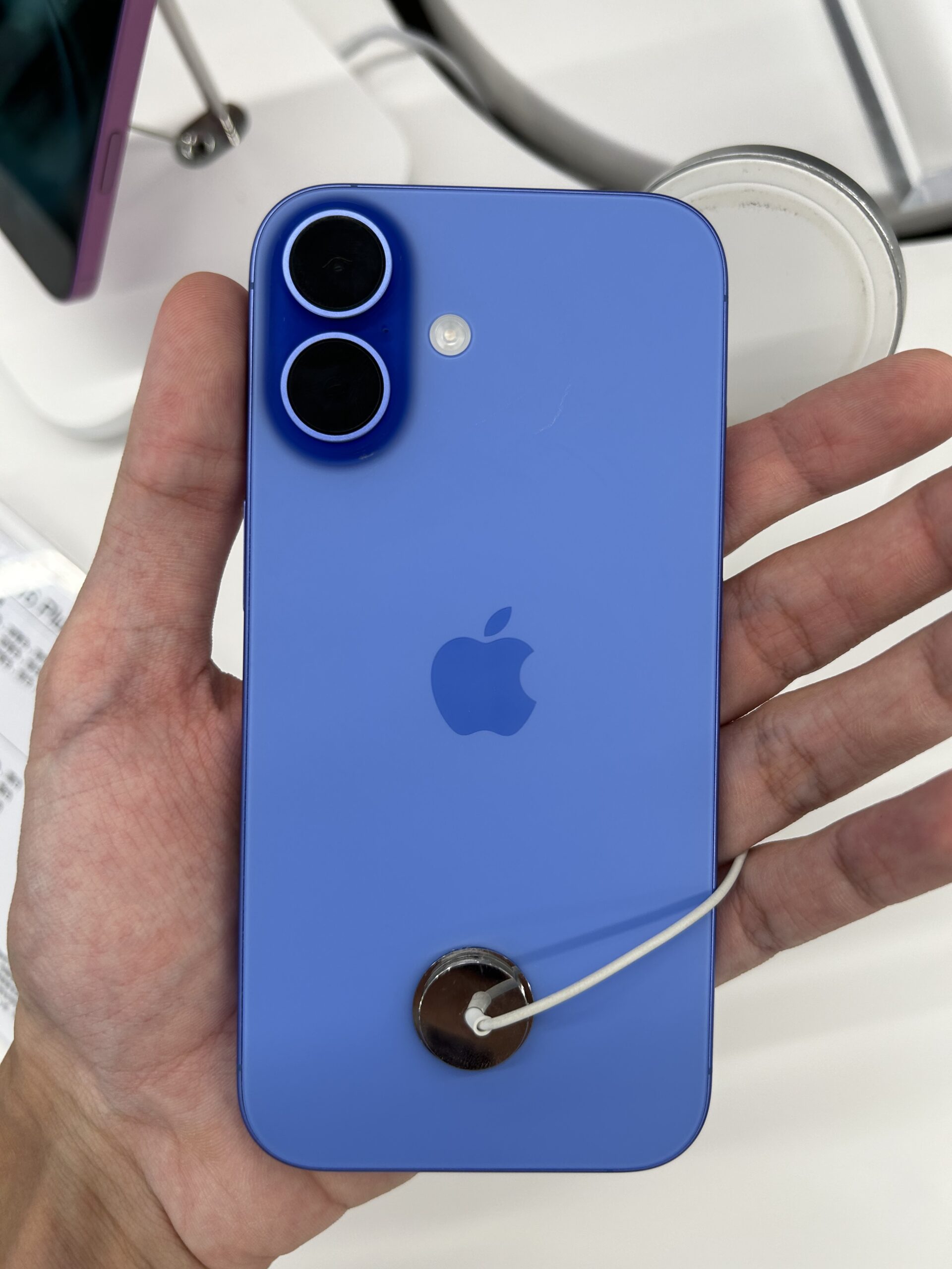 iPhone 16 held in hand, the kind of device that stops appearing in AirDrop on a Mac running macOS Tahoe