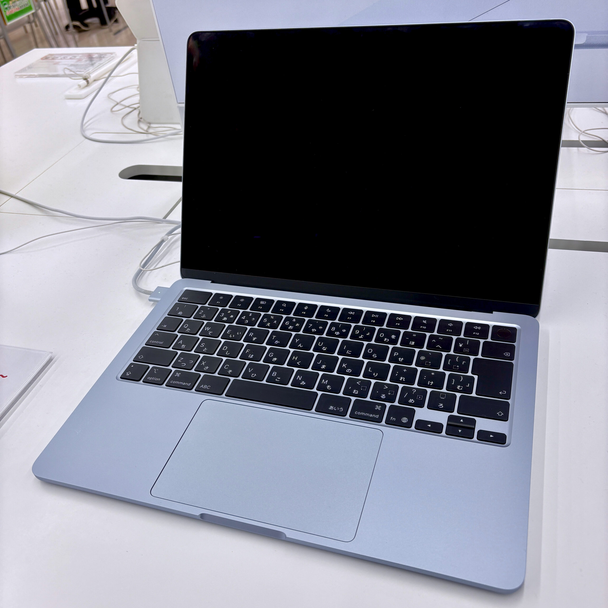 MacBook Air on a desk, used for checking AirDrop and network settings on macOS Tahoe