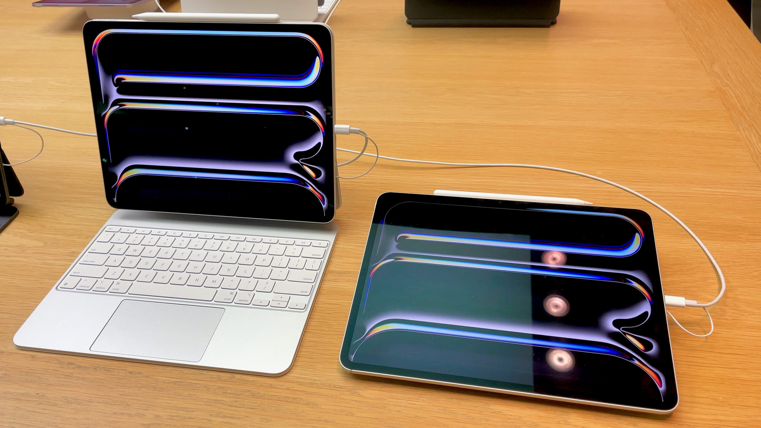 Two iPad Pro models with Magic Keyboards side by side, set up for multitasking