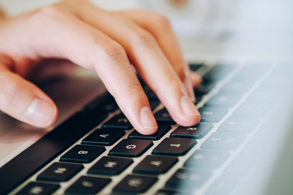 Close-up of hands typing on a laptop keyboard, representing the everyday office work Cowork is mostly used for